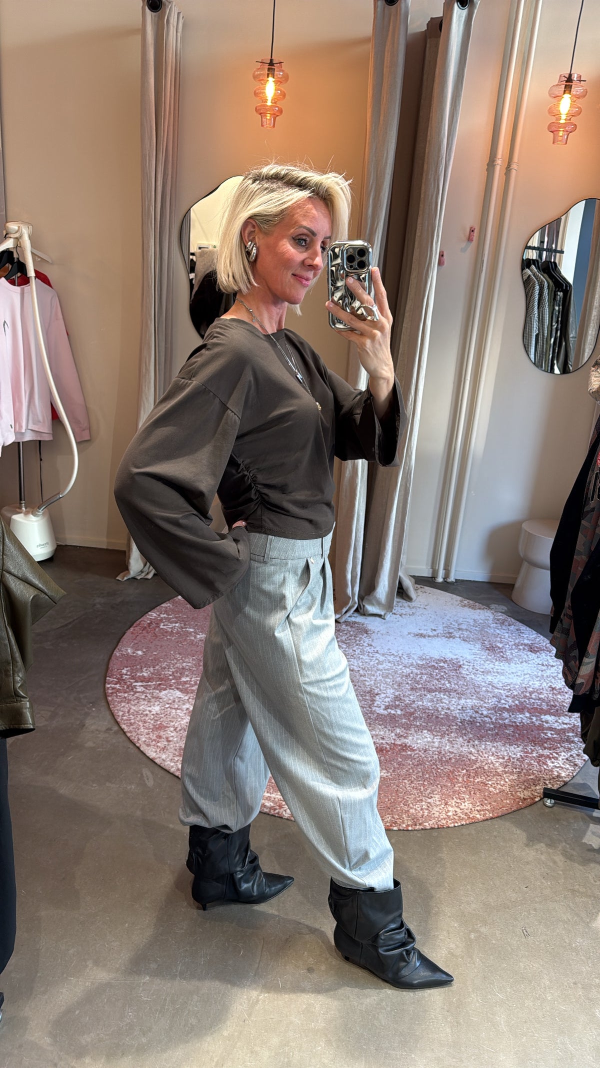zijaanzicht van model in khaki longsleeve, detail van de getailleerde pasvorm en mouwen