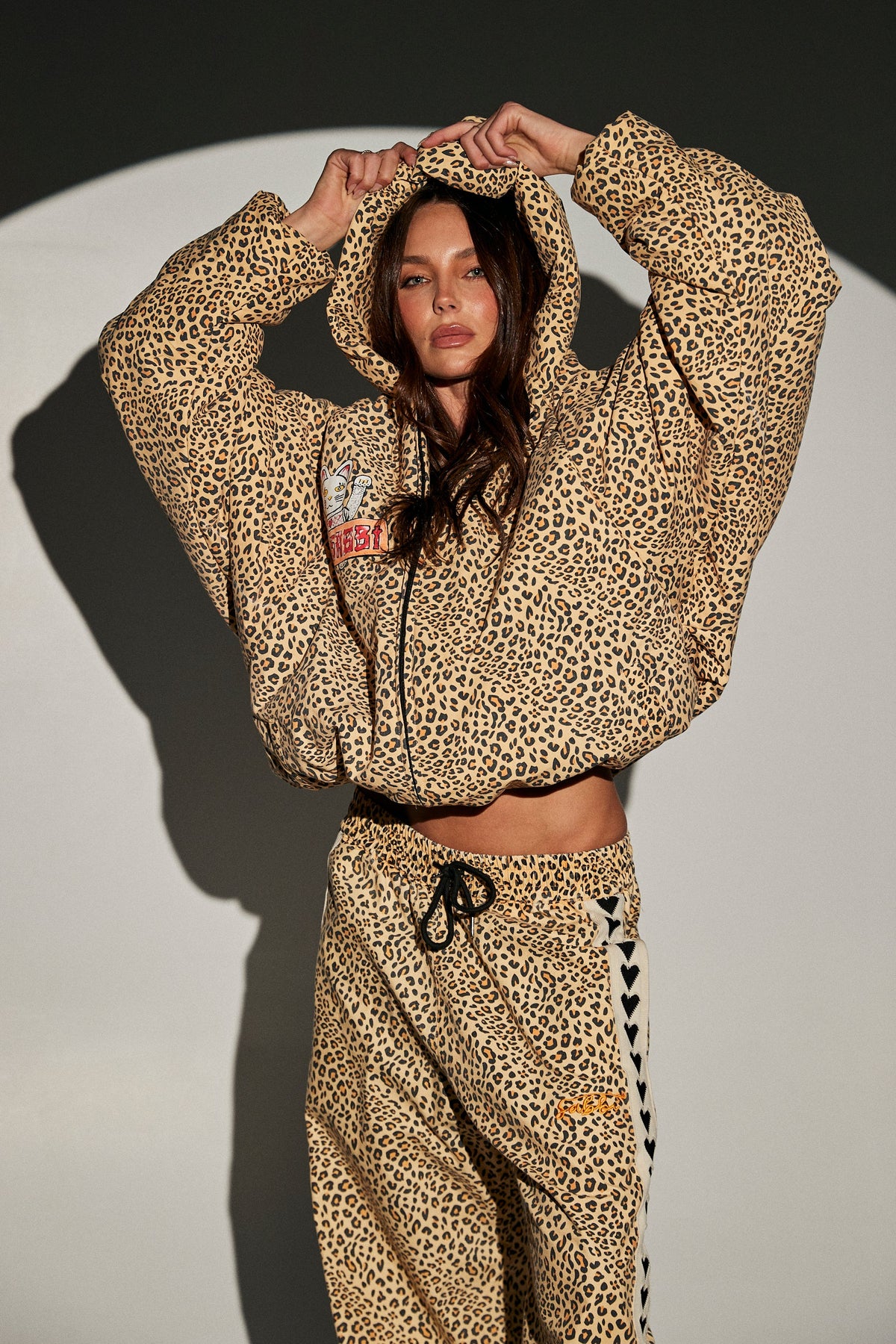 sabbi the big cat energy puffer, model draagt leopardprint set met capuchon op, vooraanzicht