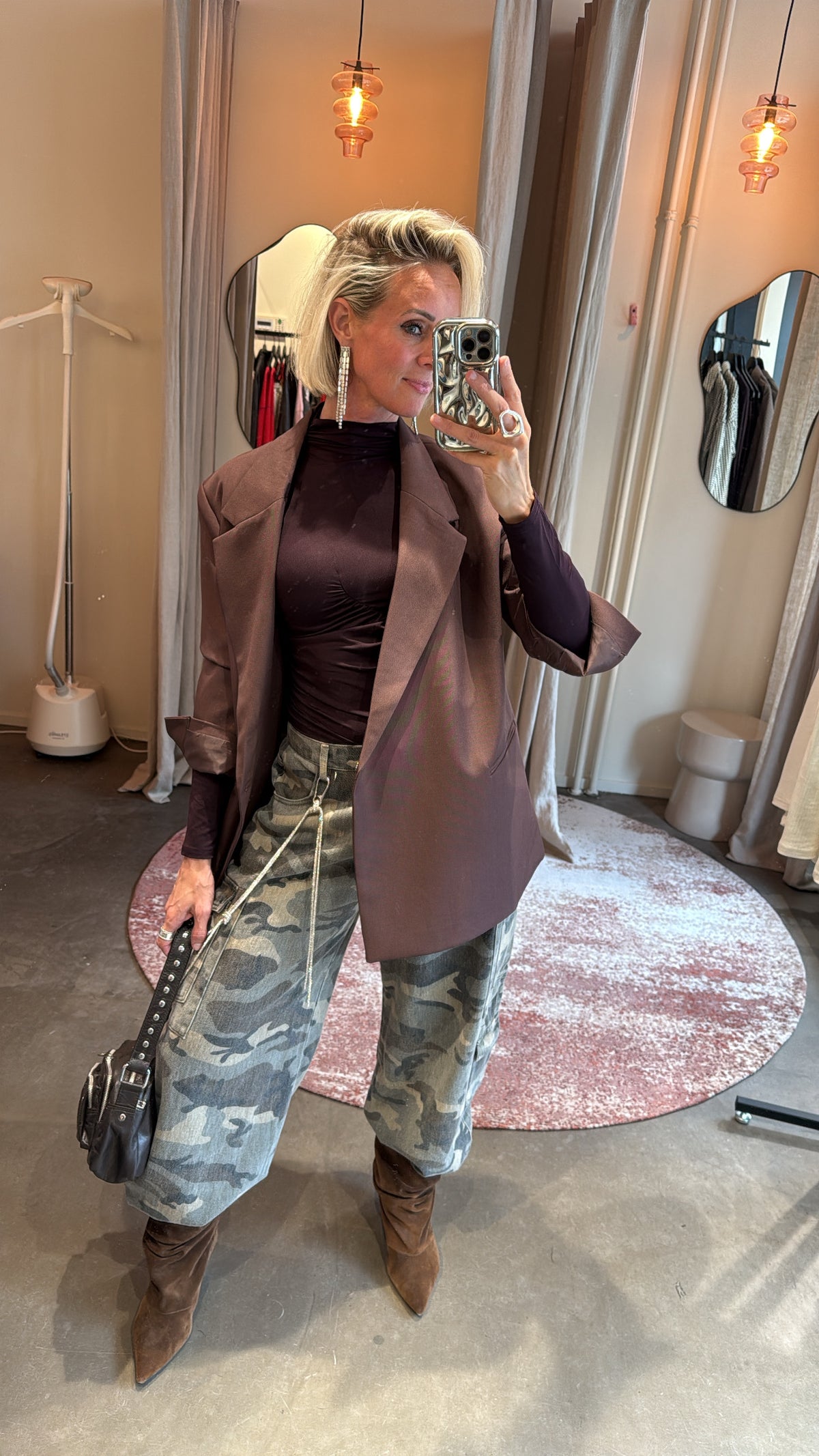 model poseert in paspiegel met plum body onder blazer, close-up vooraanzicht