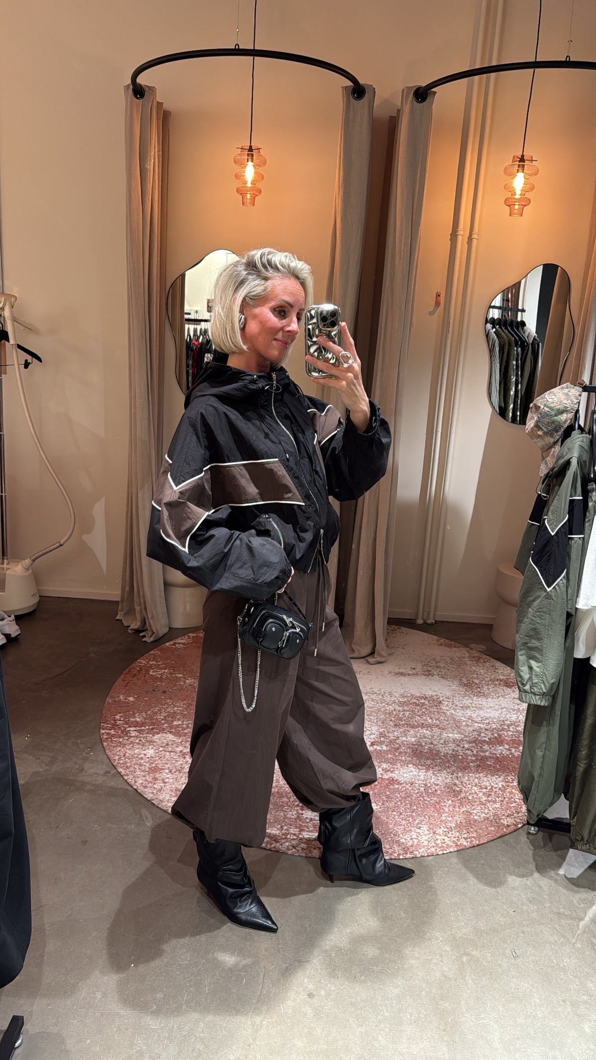 model draagt sporty track jacket in beweging, zijaanzicht met details zichtbaar