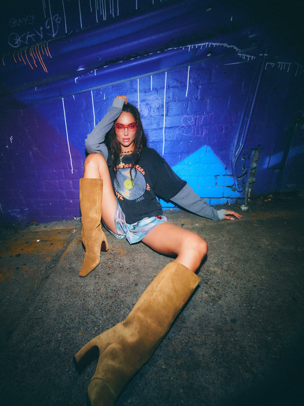 model draagt the sound club longsleeve tee van sabbi met vinylprint, zittend op straat