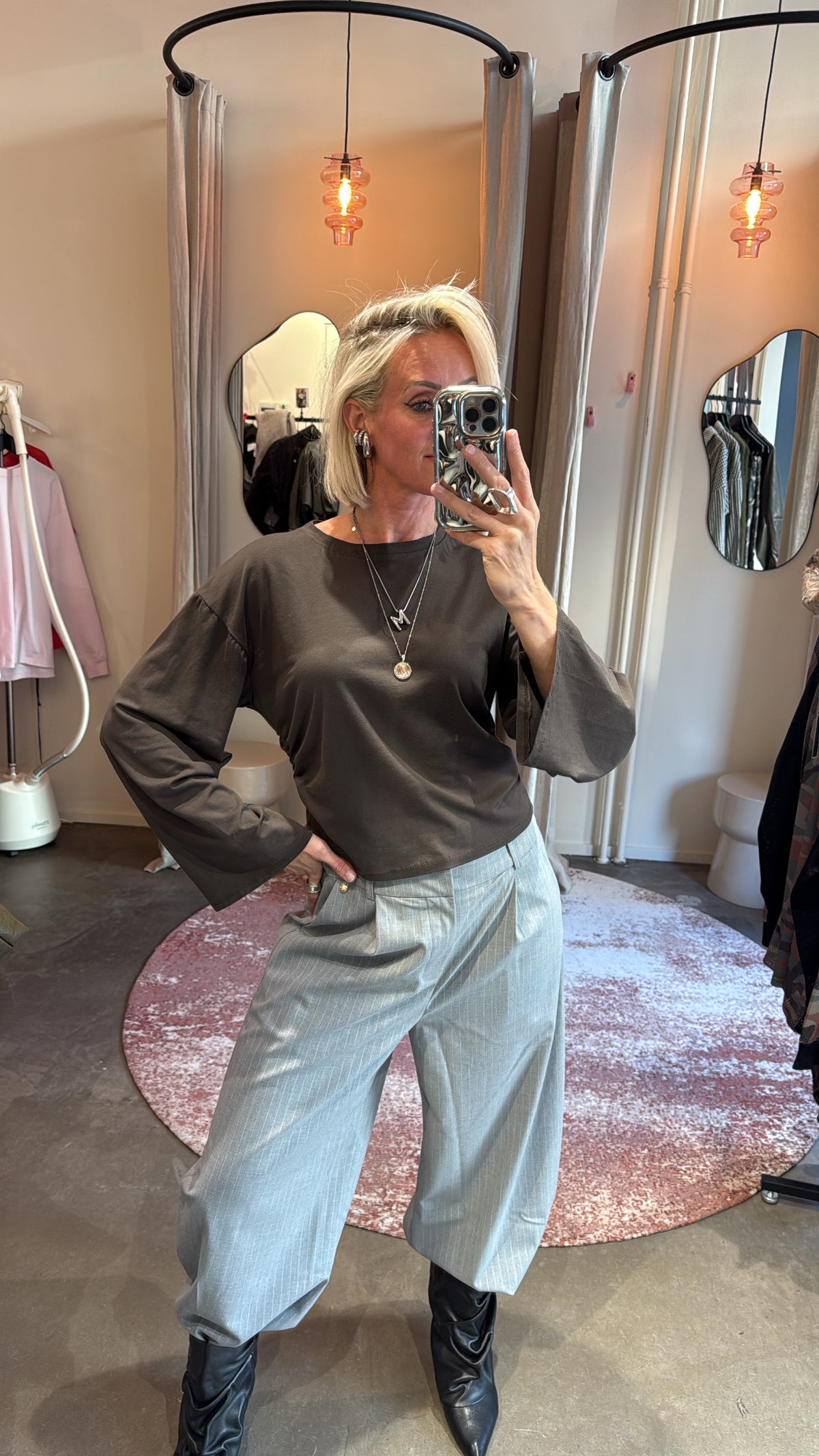 model draagt khaki longsleeve met wijde mouwen, close-up van bovenlichaam