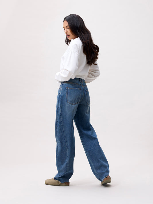 model draagt de jeans, achteraanzicht met zicht op de barrel fit