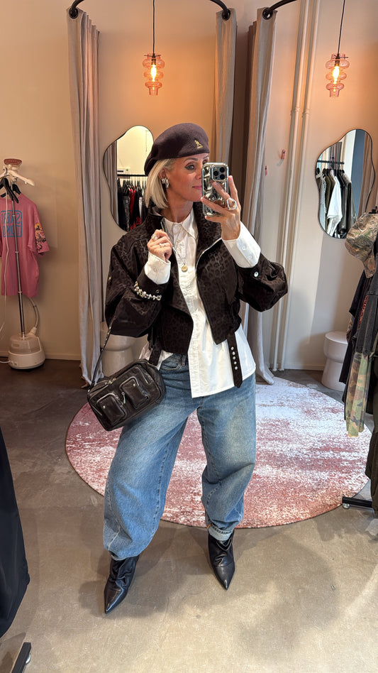 model draagt bikerjacket brown leopard open over witte blouse met baggy jeans