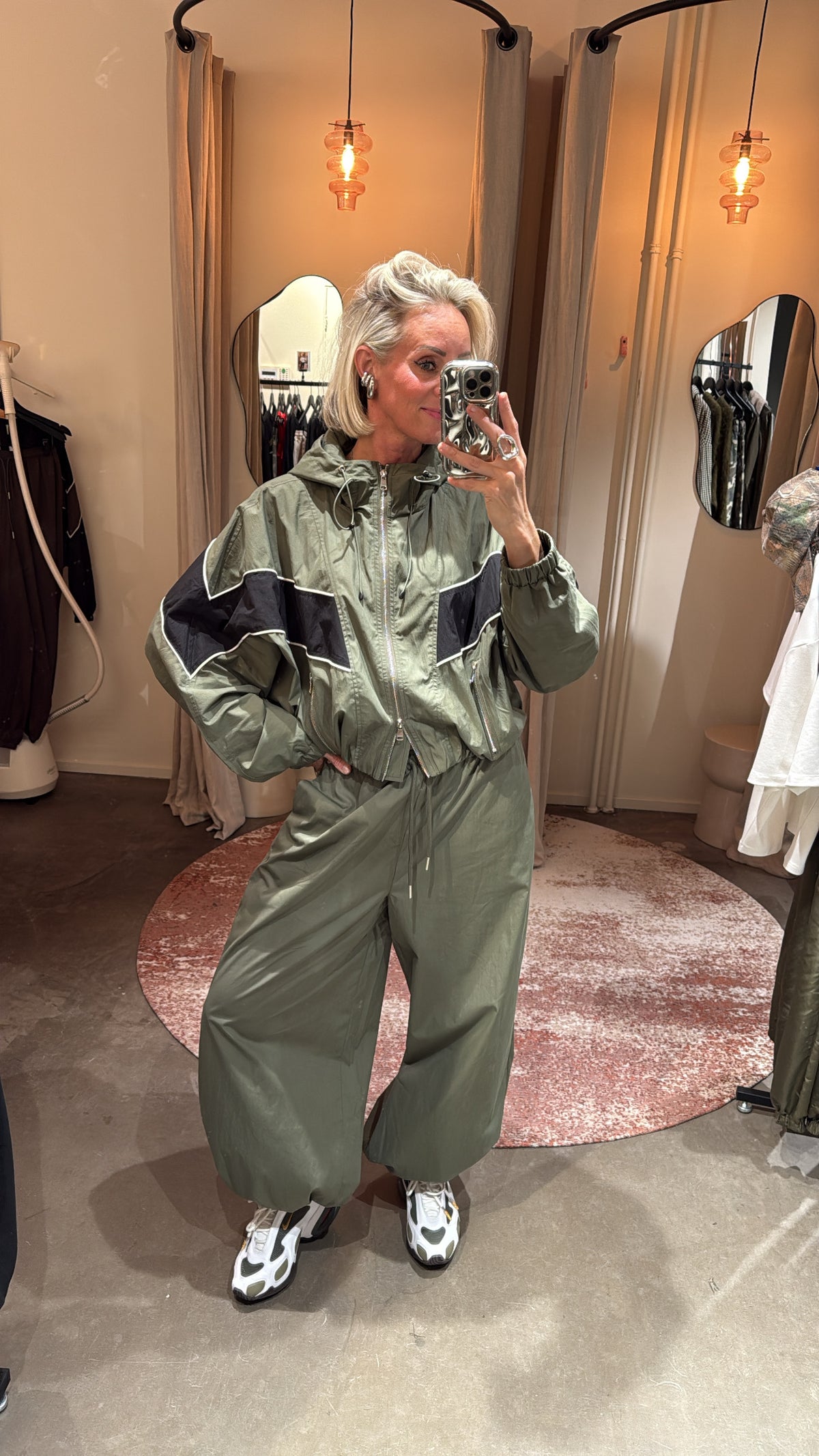 sporty track jacket green/black van studio collection, model draagt set met wijde broek, vooraanzicht