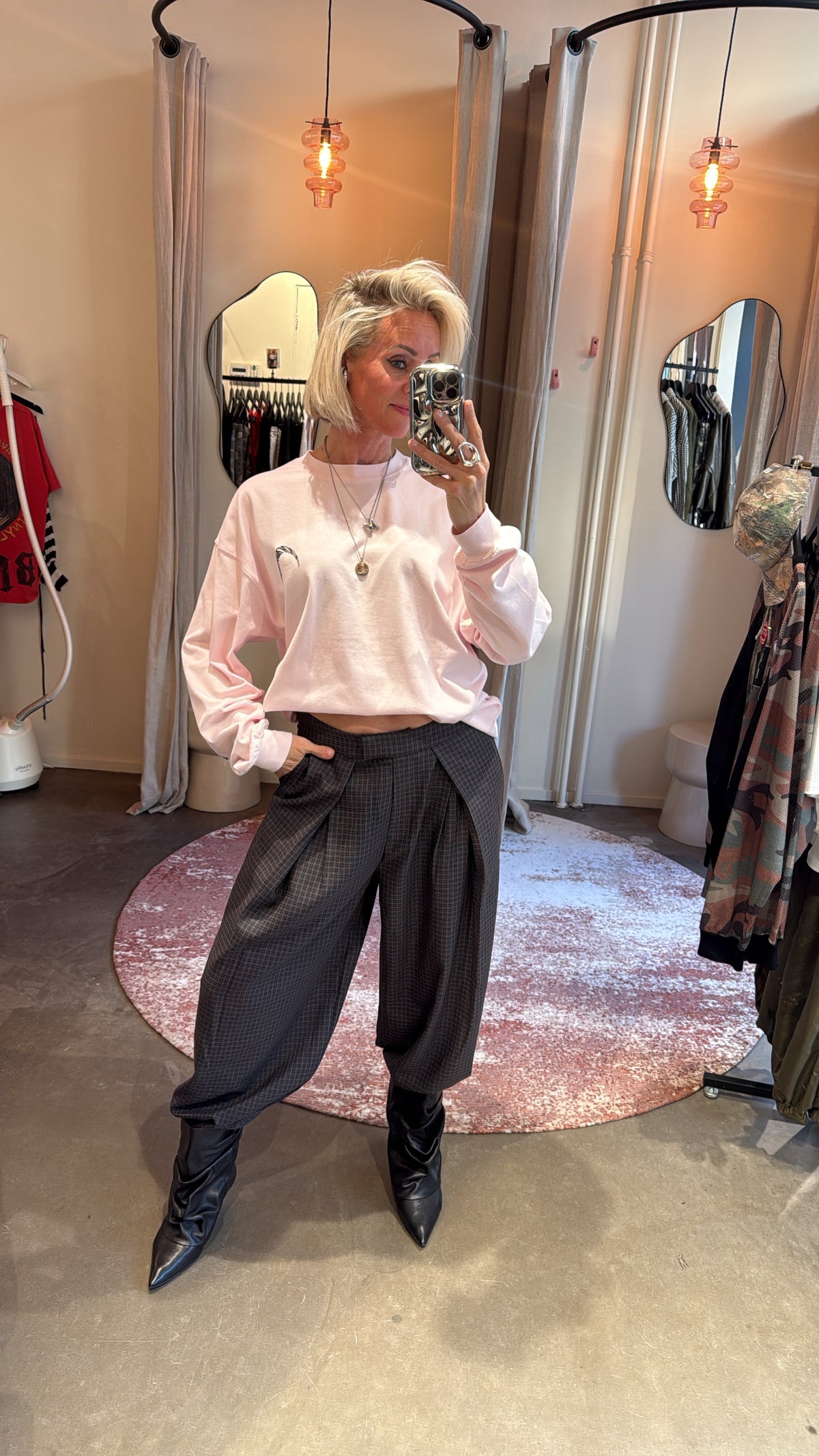 model combineert balloon pants check met roze sweater, vooraanzicht in paskamer