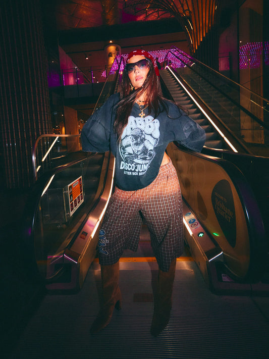 dj cat tee black van sabbi, model draagt oversized tee op roltrap, vooraanzicht