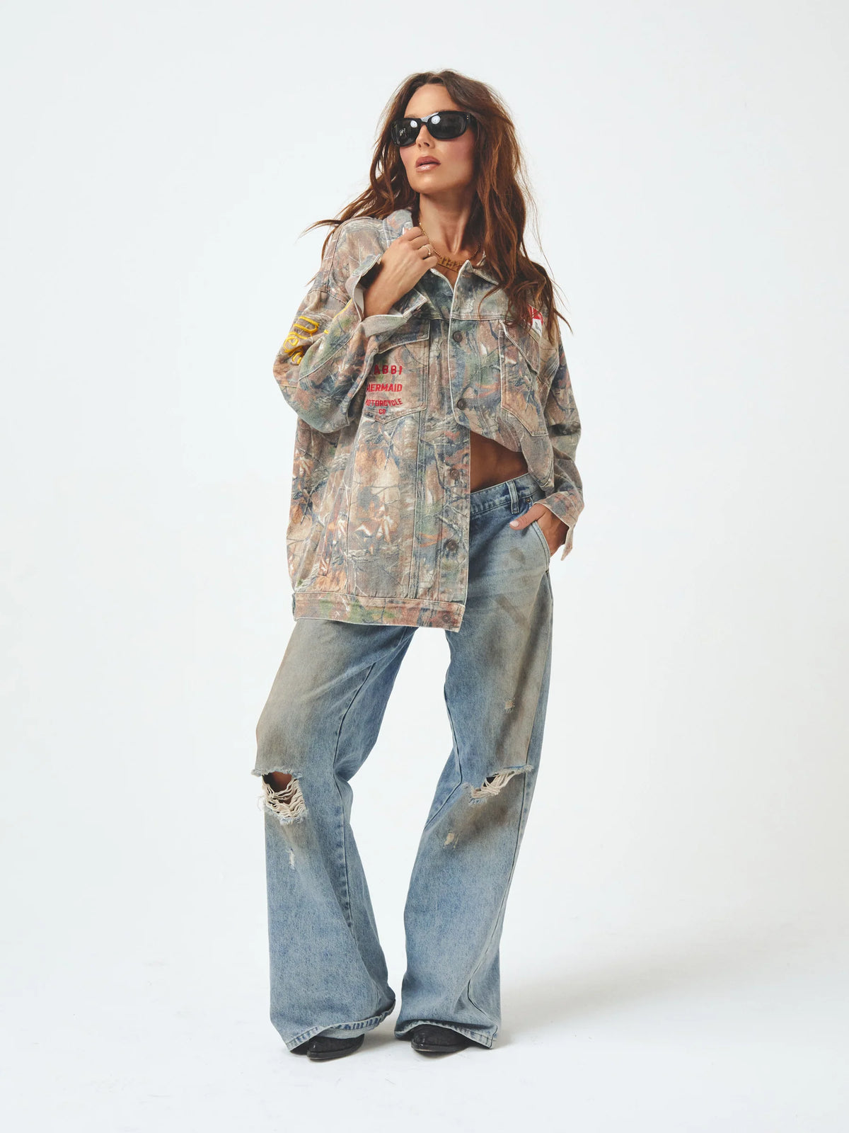 model draagt oversized jack gecombineerd met ripped jeans, volledige outfit