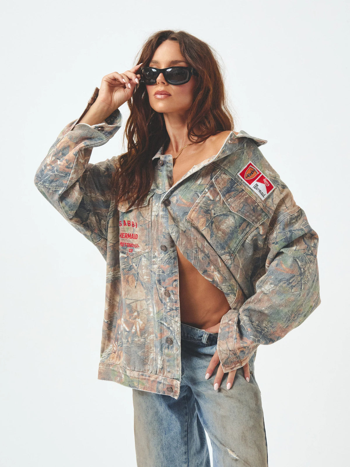 the flying mermaid wandering jacket van sabbi, model draagt camouflage denim jack met patches